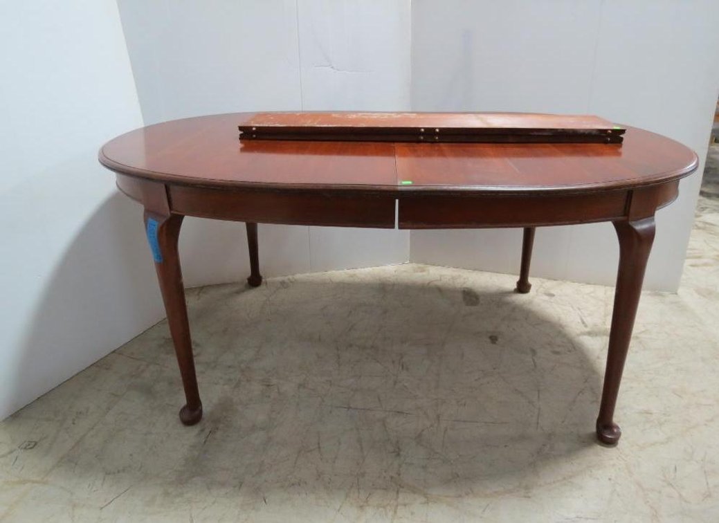 A Pennsylvania house race track oval dining room table with modified Queen Anne legs.