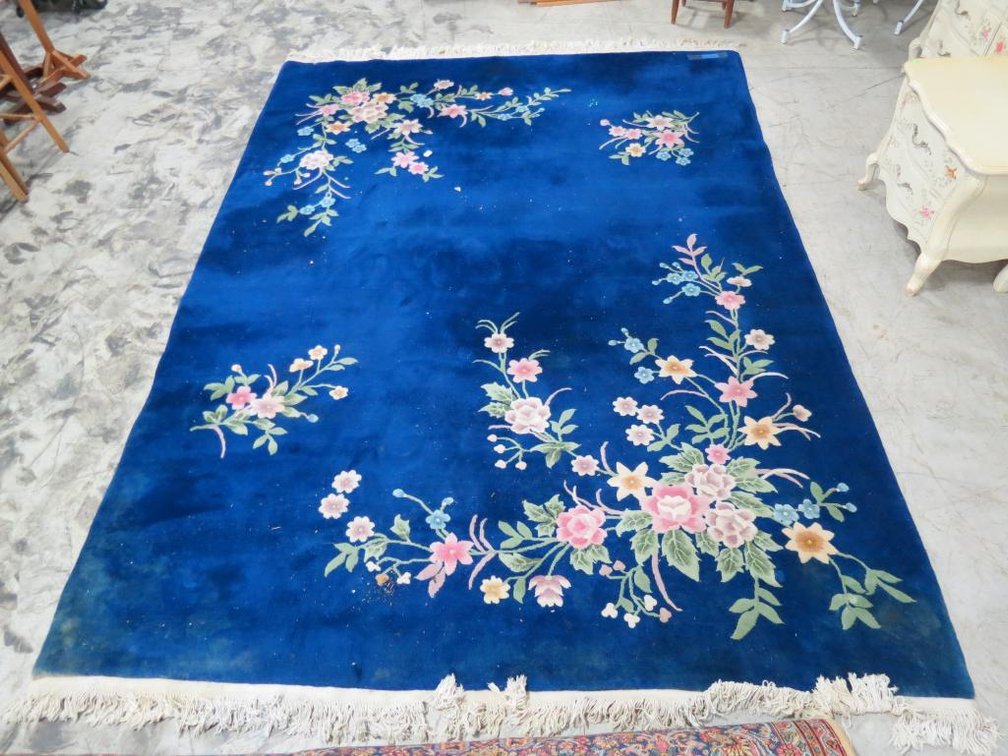A vintage, wool rug with floral designs.