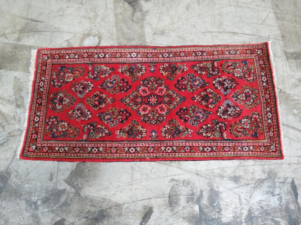 A small woven rug imported from Iran, probably wool.