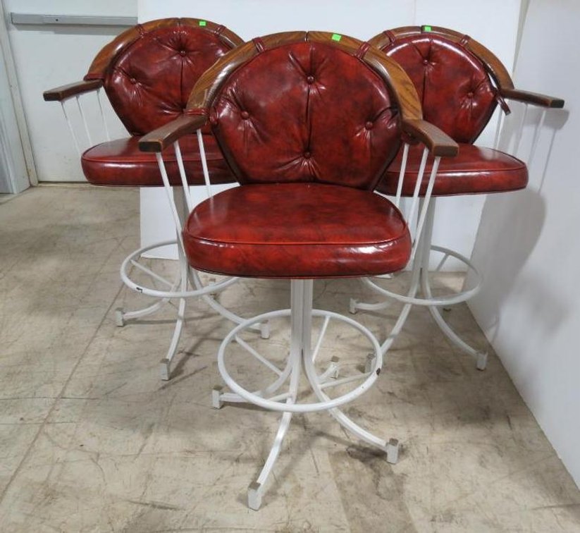 Three vintage Naugahyde, wood, and wrought iron swivel bar stools.