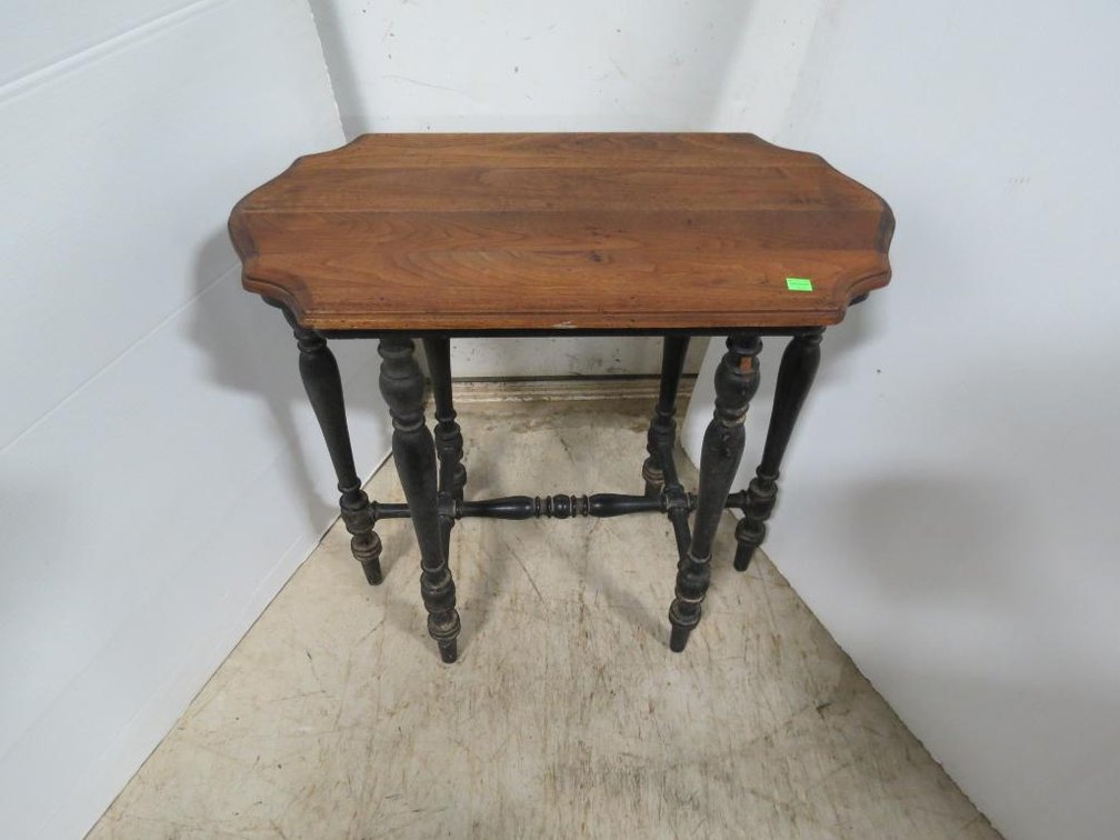 A vintage round table with spindle legs and one shelf.