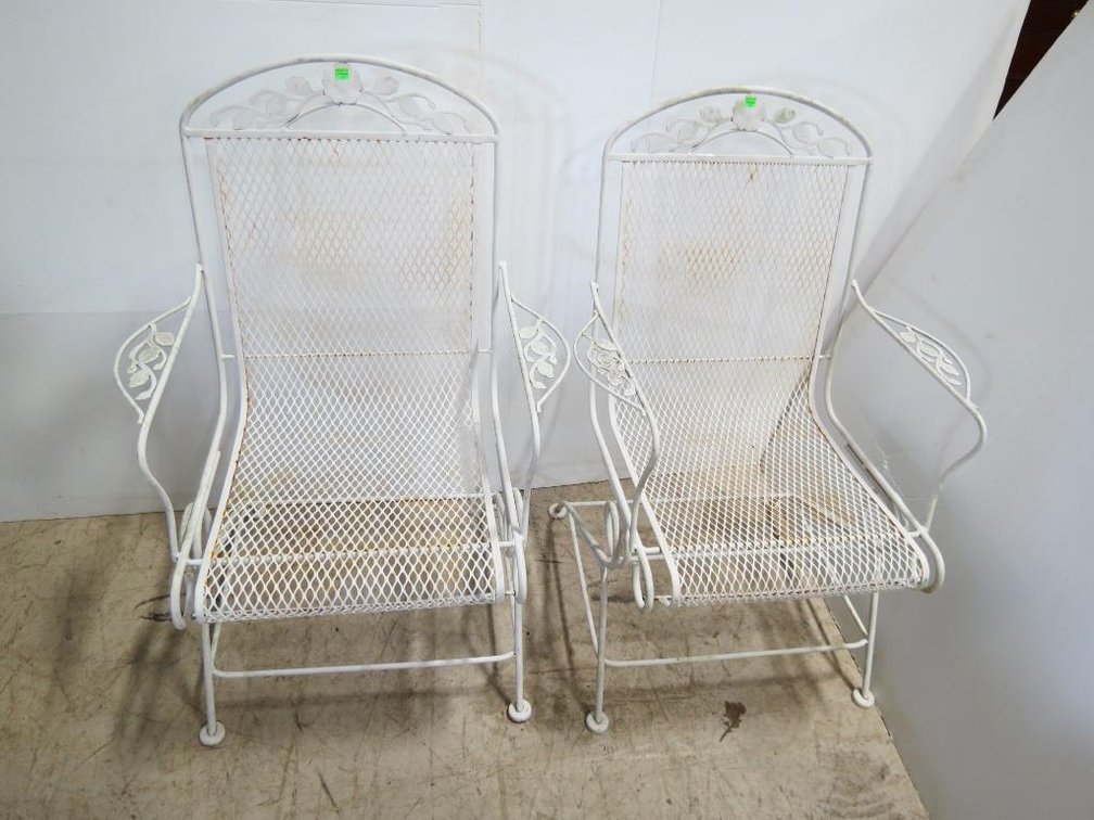 A pair of painted wrought iron chairs.