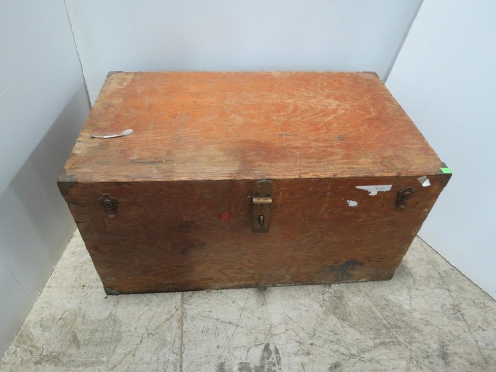 A vintage wood travel trunk with brass corners.