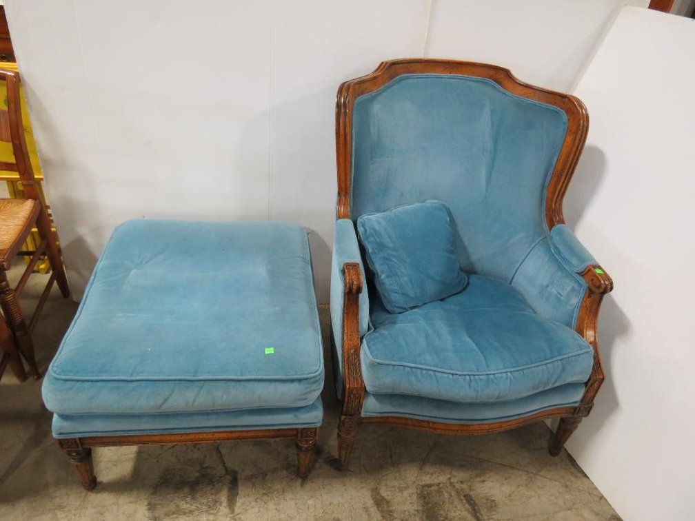 A chair and matching ottoman in blue velveteen fabric.