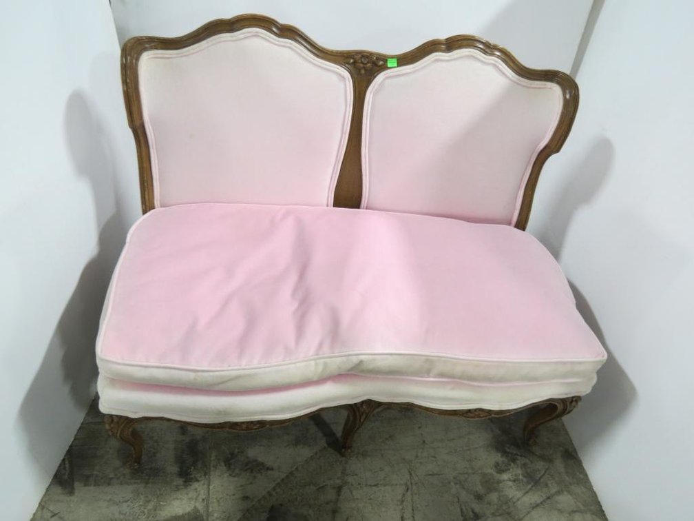 An antique love seat with pink cushions. Please preview for condition.