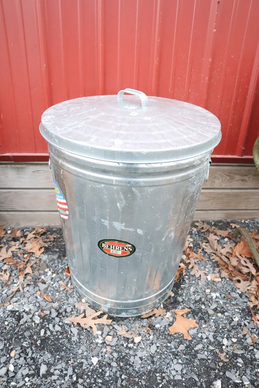 Metal Trash Can With Bag of Turf Builder and Oil Drain Container