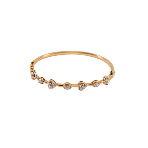 A gold bangle with heart and oval shaped diamonds and imported setting