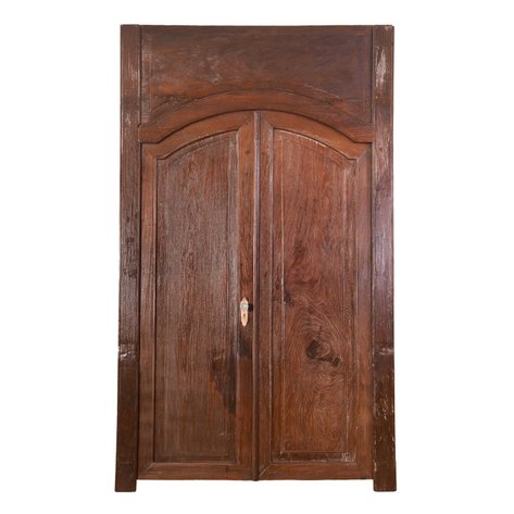 A grand heritage double-leaf/butterfly door set with arched transom and raised center panels