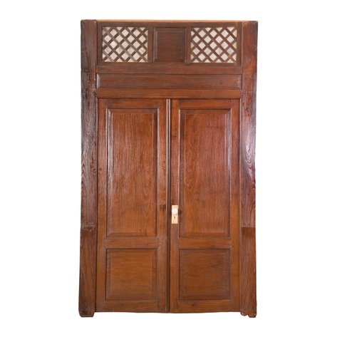 A grand heritage double-leaf internal door set with capiz latticework transom and raised center panels