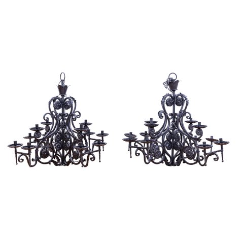 A pair of grand 12-arm wrought-iron chandeliers by Arte Español adorned with hand-forged rosette medallions