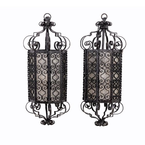 A pair of wrought-iron hanging lanterns by Arte Español featuring intricate scrollwork grilles