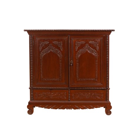 A Neo-Gothic comoda with carved ogee arch panels and spool moldings