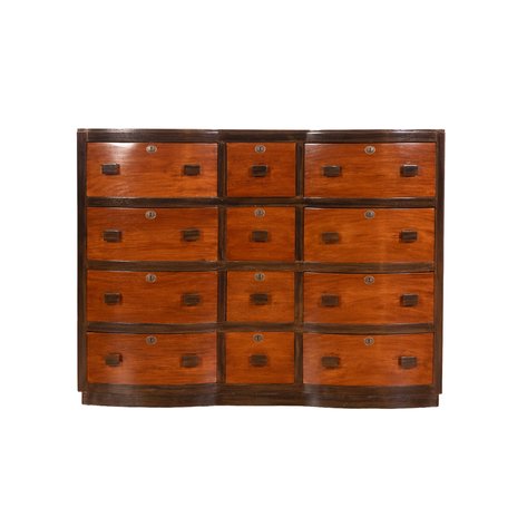 A mid-century modern serpentine-front chest of drawers with block pulls and faux escutcheons
