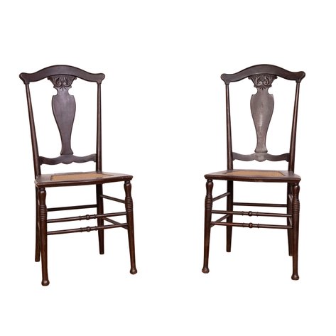 A pair of Art Nouveau side chairs with carved fiddle-back splats topped by scrolling leaf motifs