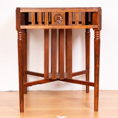 A transitional Art Deco center table featuring slatted apron with central rosettes and an unusual under-shelf partially enclosed by flanking vertical struts