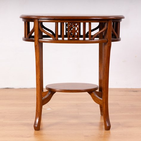 A transitional Art Deco center table featuring a slatted and curved spandrel apron with lattice shield medallions