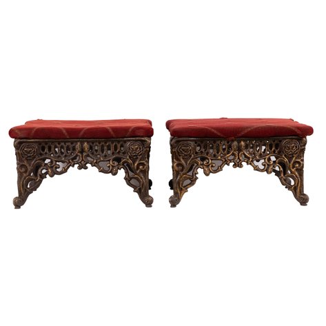 A pair of Victorian Revival upholstered footstools featuring openwork scrolling aprons and legs