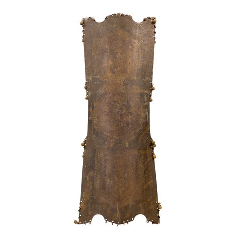A kalasag from the Moro or Maranao tradition with intricate repoussé and punched floral or geometric scrollwork designs