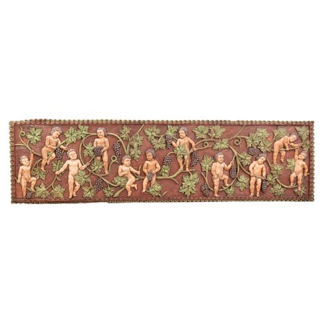 An impressive high-relief carved altar frontal depicting putti amidst trailing grapevines