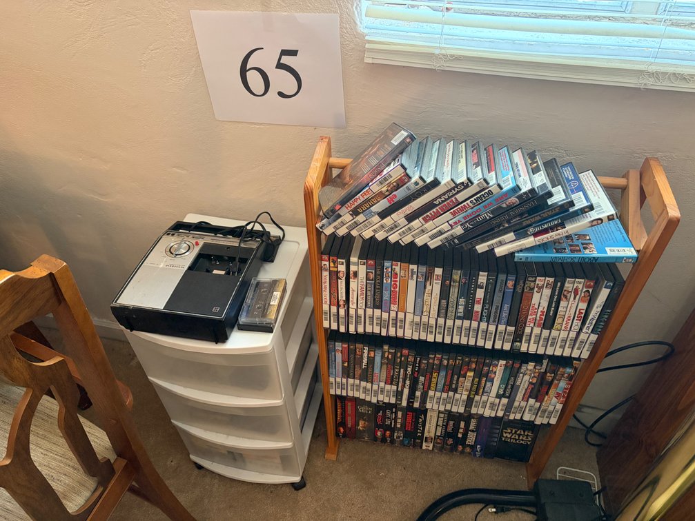 RACK OF DVDS; STORAGE WITH WHEELS; DOZENS OF CASSETTES AND CASSETTE PLAYER