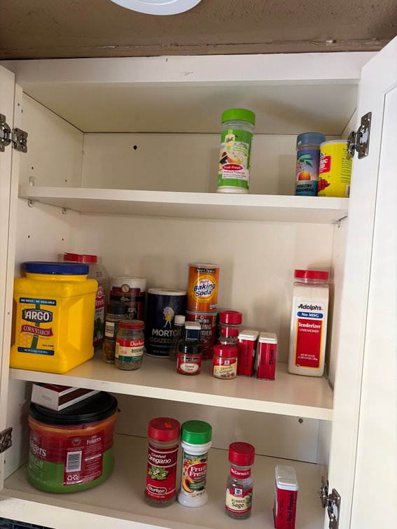 Cabinet of seasonings; cabinet of mugs.