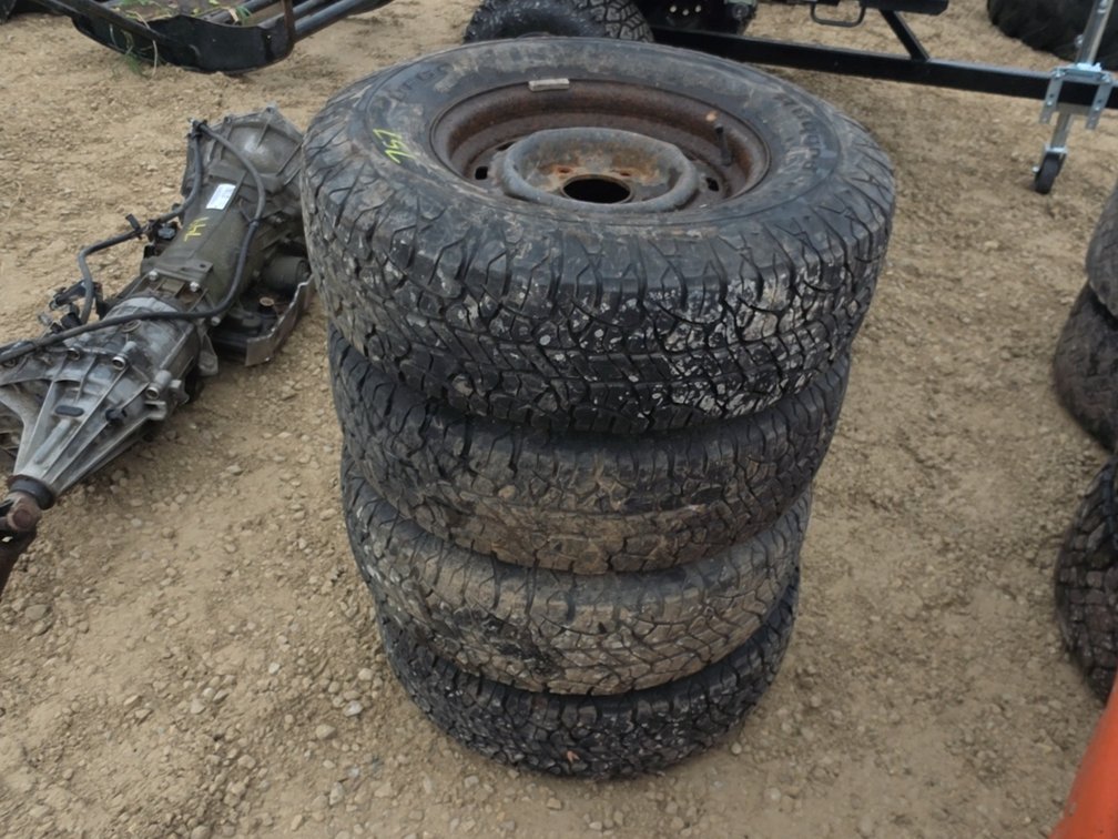(4) 235/75 R15 TIRES ON 5 BOLT FORD RIMS