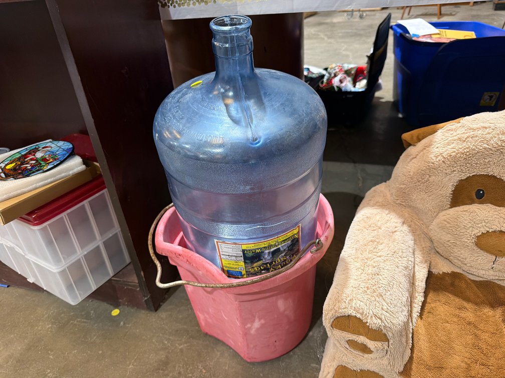 PLASTIC WATER BOTTLE AND RED BUCKET