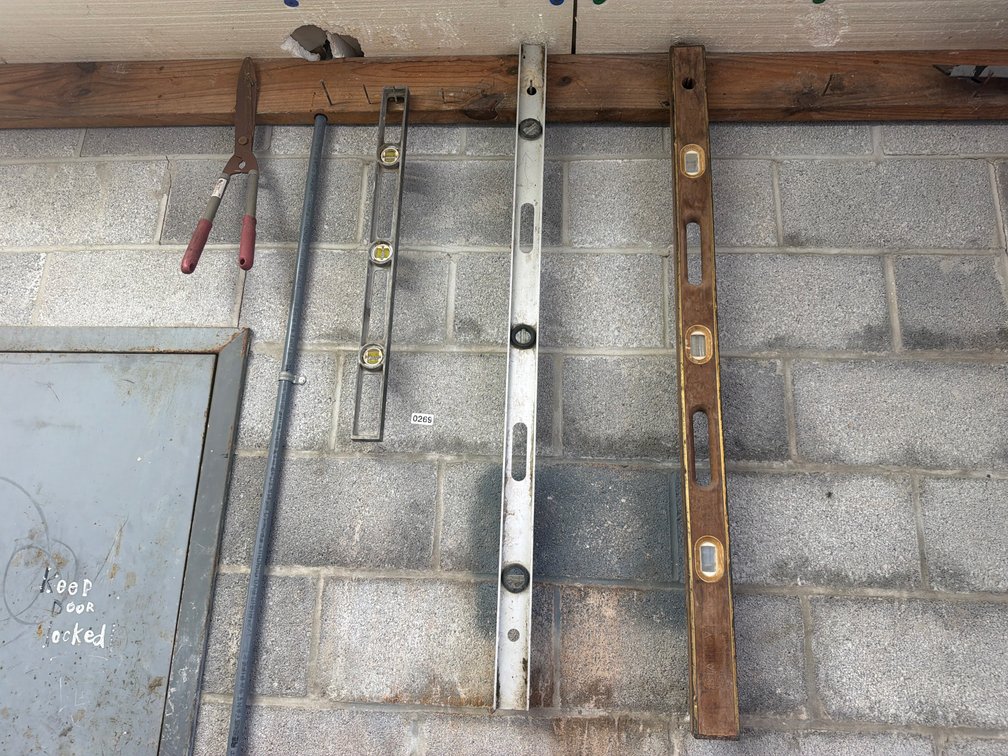 LEVELS, BOLT CUTTERS, AND OTHER TOOLS HANGING