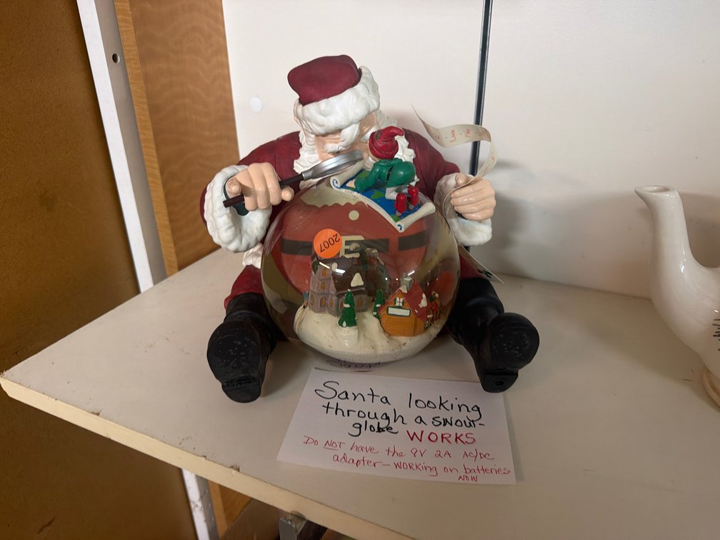 SANTA LOOKING THROUGH A SNOW GLOBE