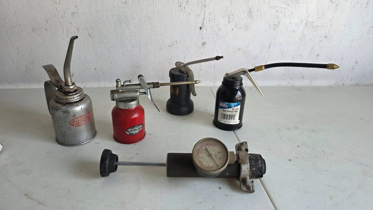Five Various Oil Cans and a Pressure Gauge Tool