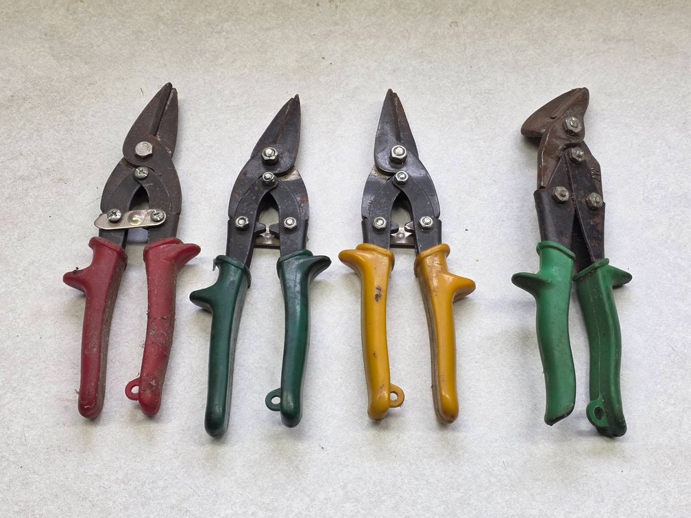 Four Tin Snips: Three Straight with Serrated Teeth and One Curved Bladed