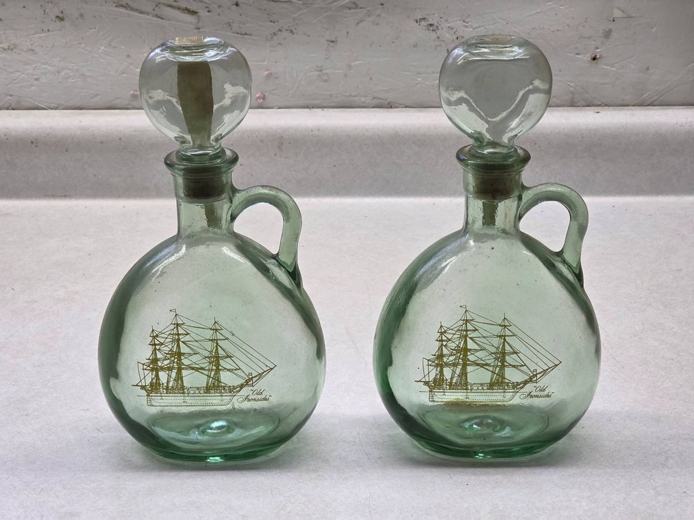 Antique Glass Whiskey Bottles with Old Iron Sides Depiction