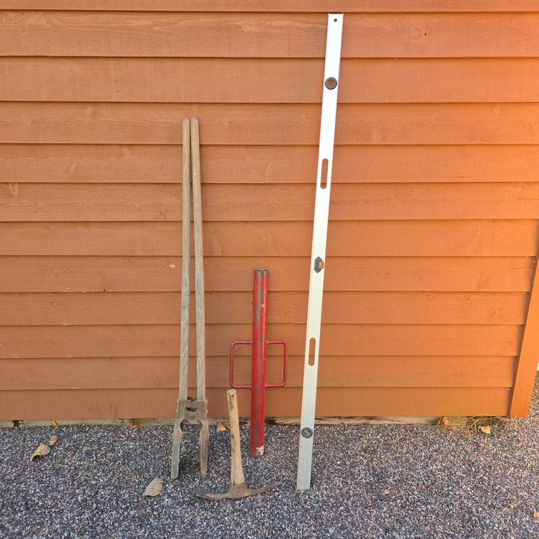 Four Garden Tools: Post Hole Digger, Metal Tamper, Pickaxe, and Aluminum Level