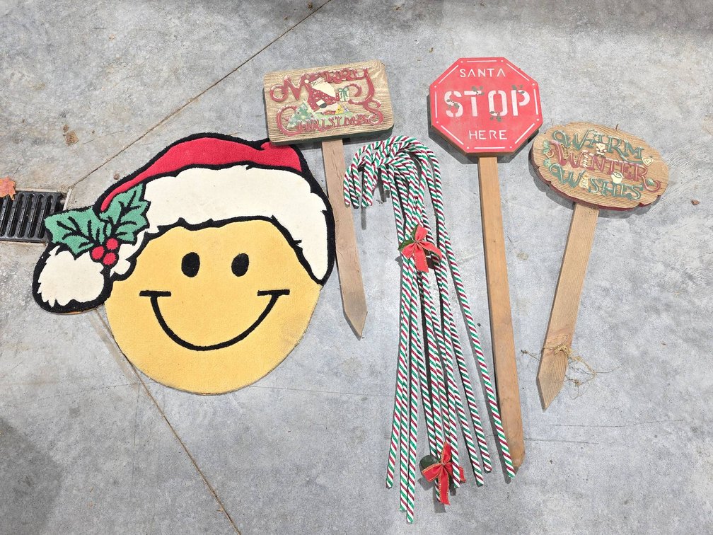 Christmas Decorations Lot With Smiley Face Santa Hat Rug, Signs, and Plastic Candy Cane Decorations