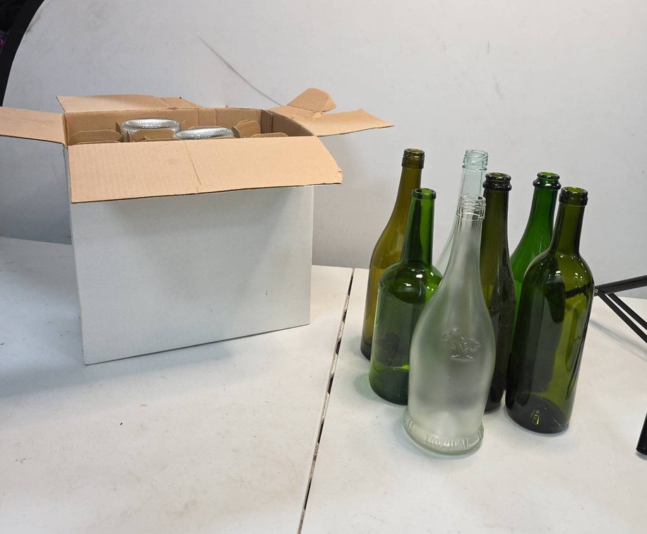 9 Glass Wine Bottles in Various Colors Including Green, Clear, and Frosted Styles