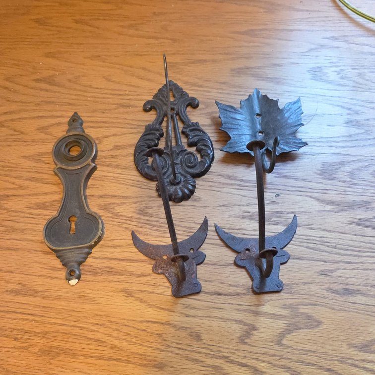 Five Pieces: Assorted Decorative Cast Iron Hooks and Ornate Keyhole Plate