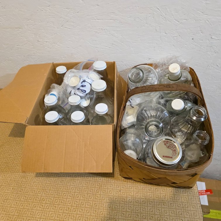 Approximately 15 Clear Maple Syrup Bottles With Lids in Basket and Cardboard Box