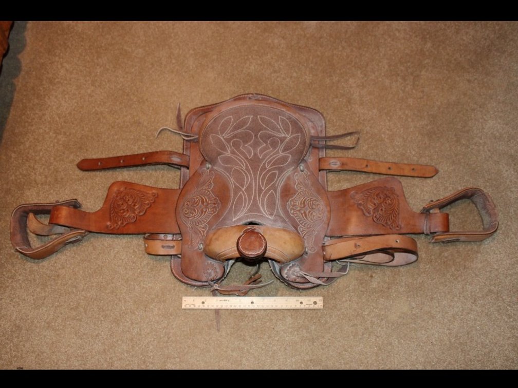 Tooled Leather Youth Pony Saddle. From Back To Horn, Measures 13 Inches. Underneath Width Is 14 Inches.