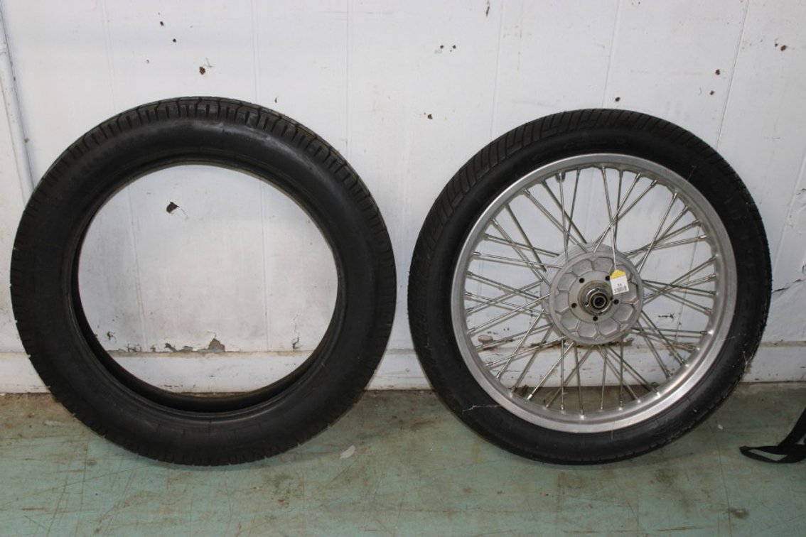 Motorcycle Wheel And Two Tires. Tire Mounted To The Wheel Is A 3.25-19.54. Unmounted Tire Is A Size 4.00-18. 64P Block K.