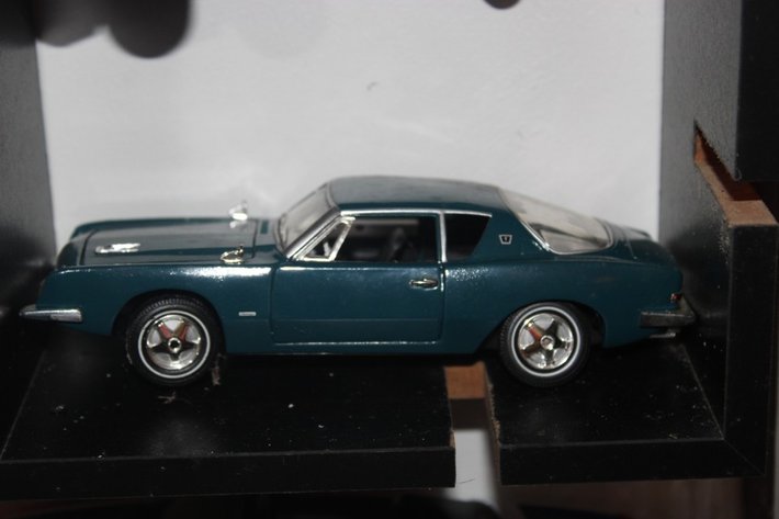 Image for Four Diecast Cars and Display Shelves. Three Are 1:32 Scale, One Is 1:24 Scale. Signature 1961 Chevy Impala, New Way 1970 Dodge Challenger, Signature 1963 Studebaker Missing a Wheel, and 2004 Thunderbird Fighting Illini