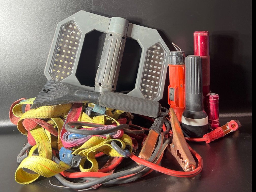 Emergency and Utility Equipment Lot Featuring Straps, Jumper Cables, Flashlights, and Work Light