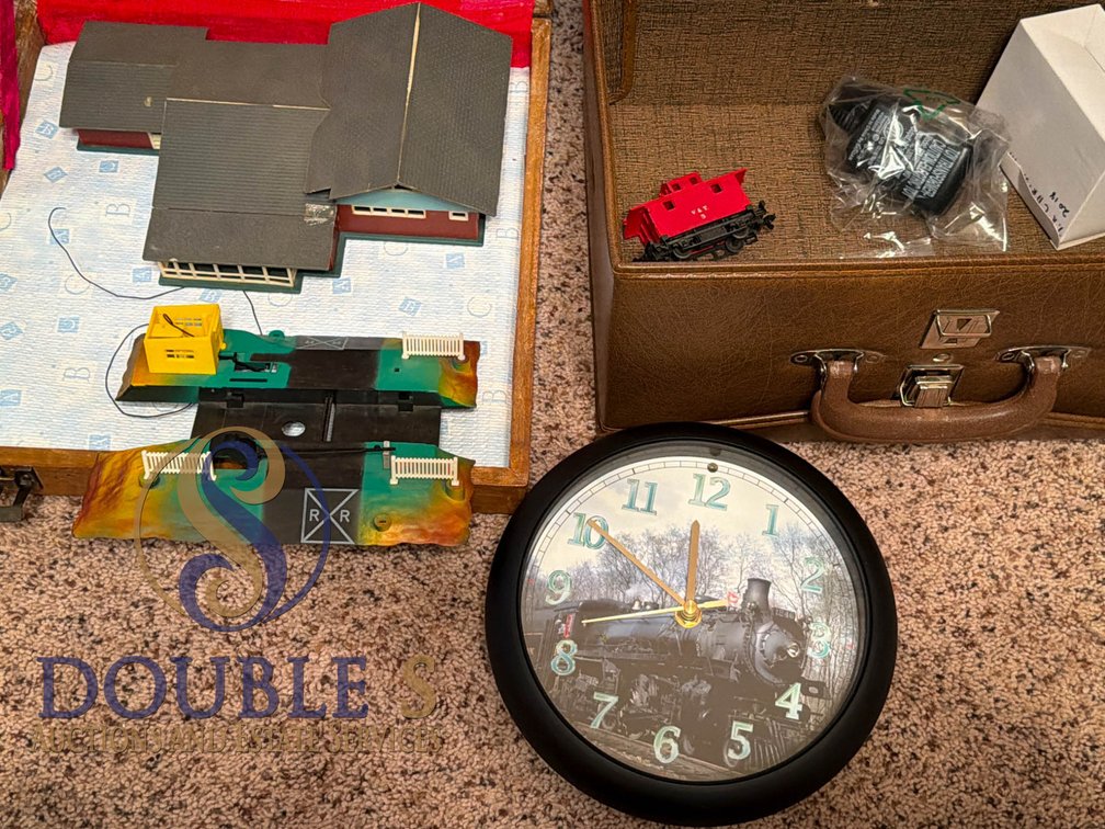 Model Train Set with Buildings, Track Components, and Locomotive Clock