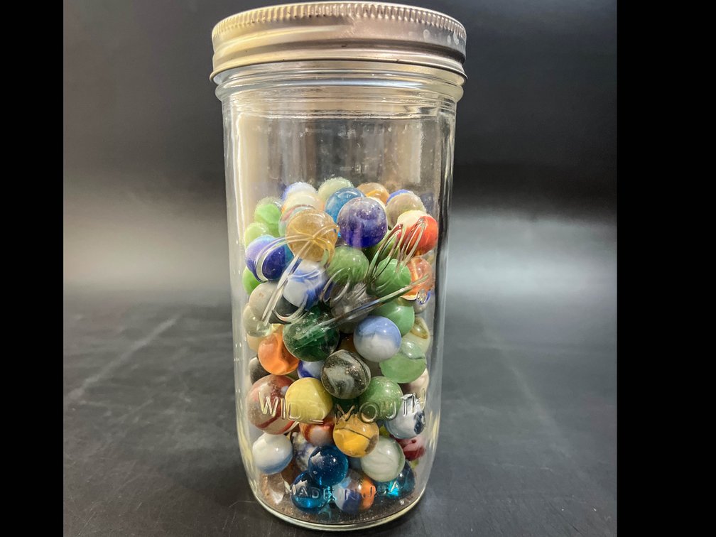 7” glass jar of marbles 