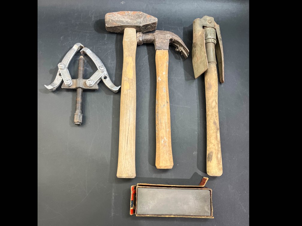 Tools, two jaw gear puller, hammers, sharpening stone, & military pick axe 