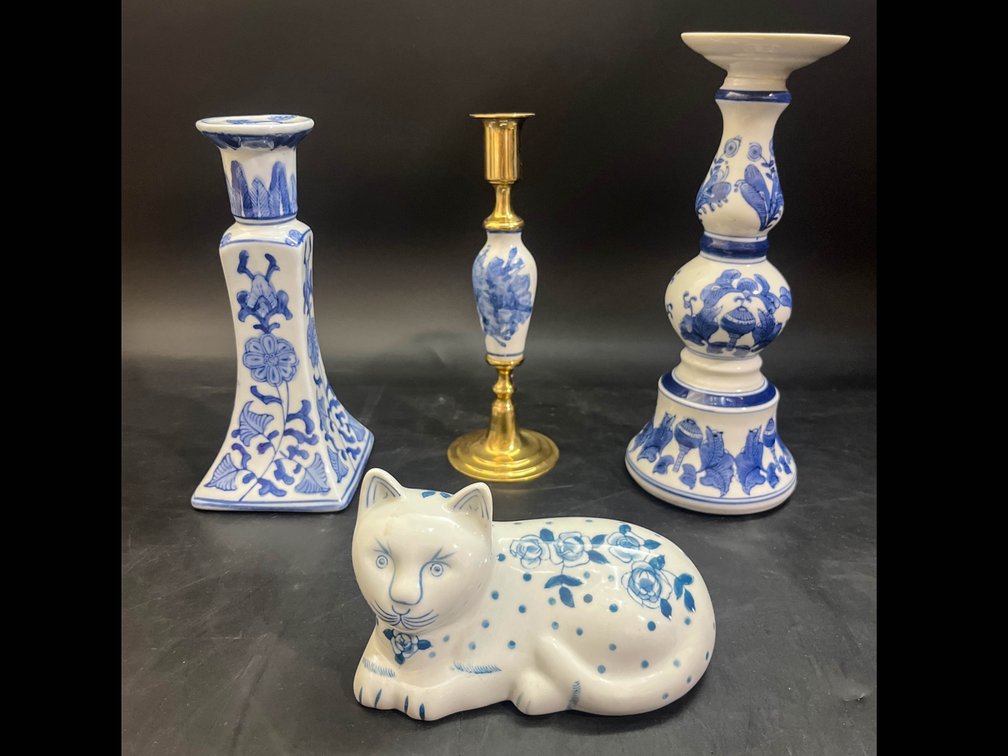 Two porcelain candlestick holders, one brass candlestick holder, and porcelain cat figurine 