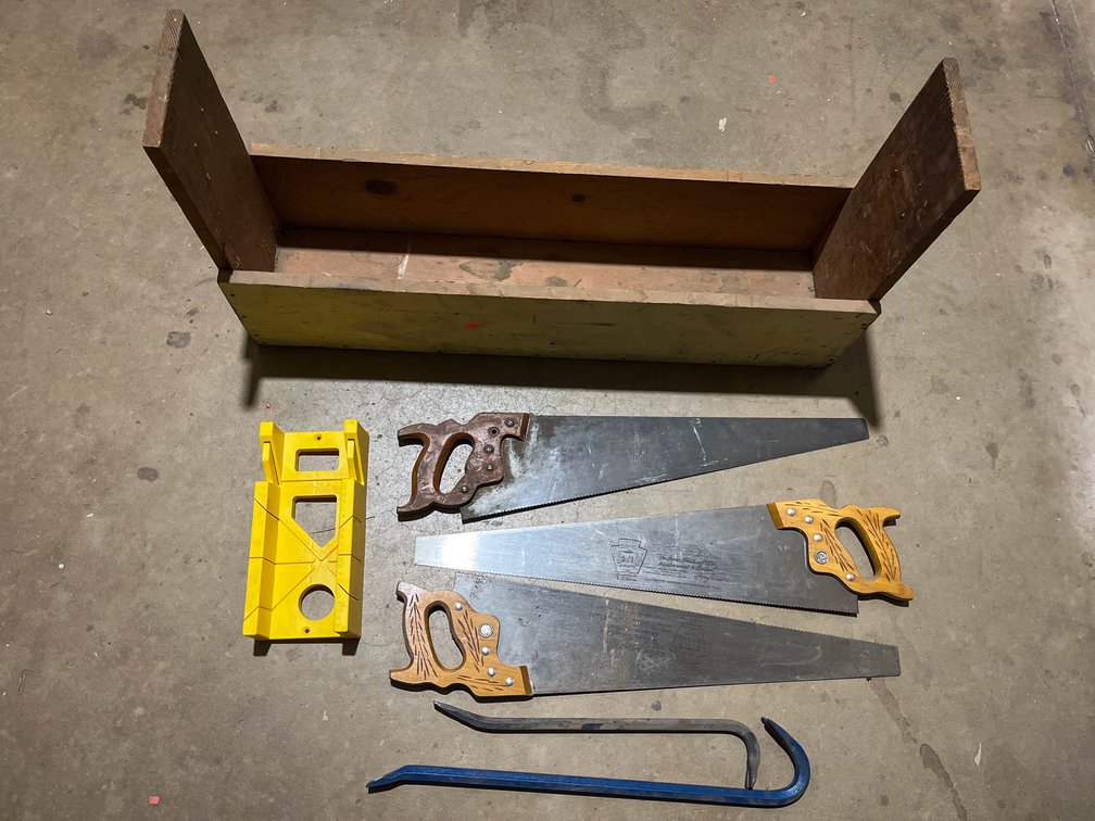 Three handsaws, two crow bars, miterbox, and storage box