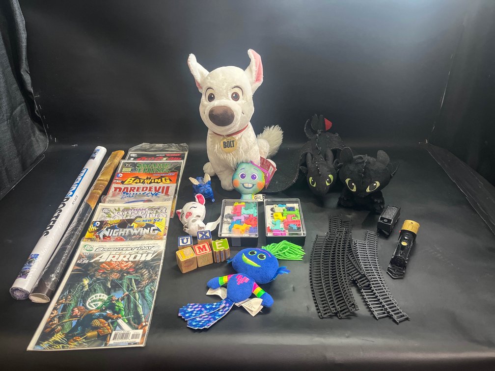 Comic books, posters, plush toys, train with tracks, blocks, and dog pile and cat stacks game