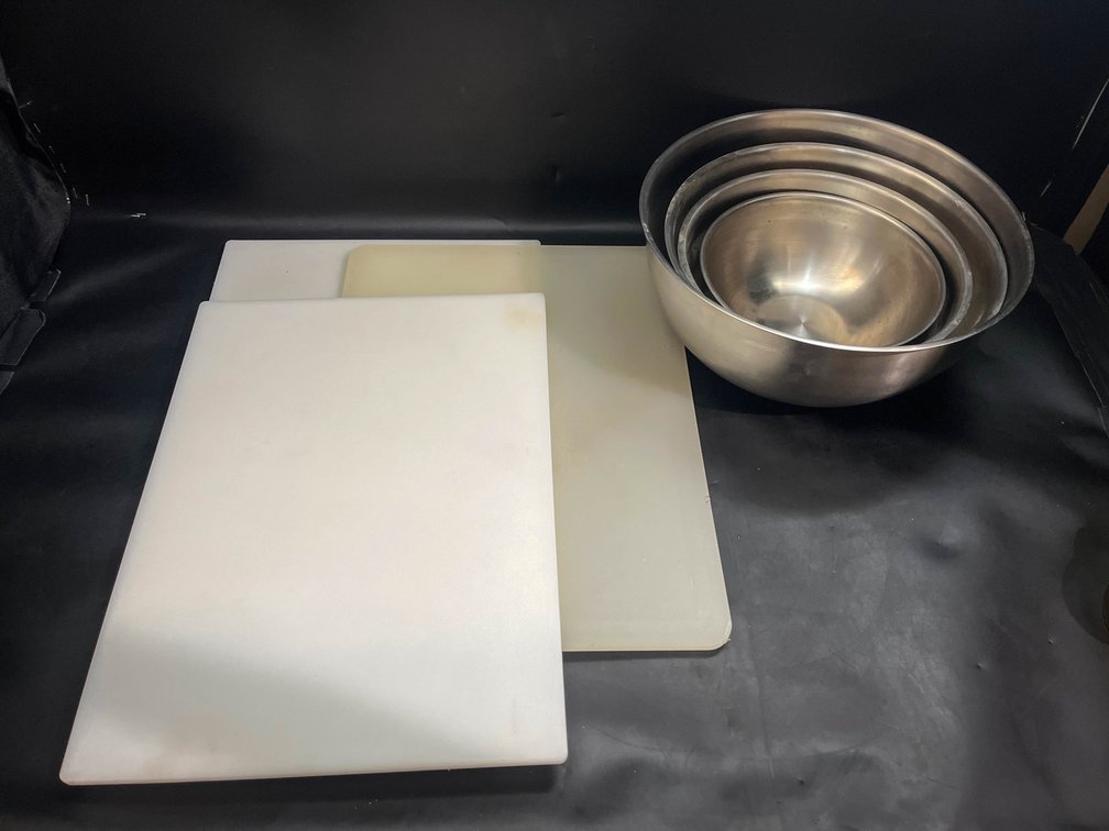 Four metal mixing bowls, and three large cutting boards 