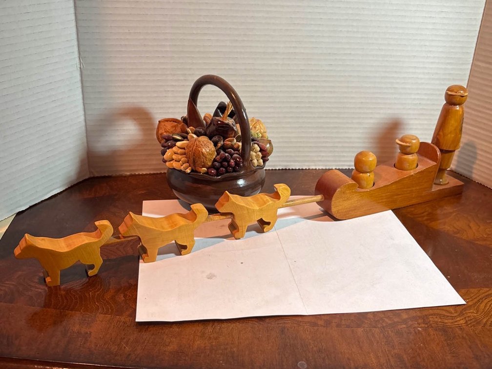 Wooden Sleigh, Reindeer Figurines, and Decorative Basket With Dried Items