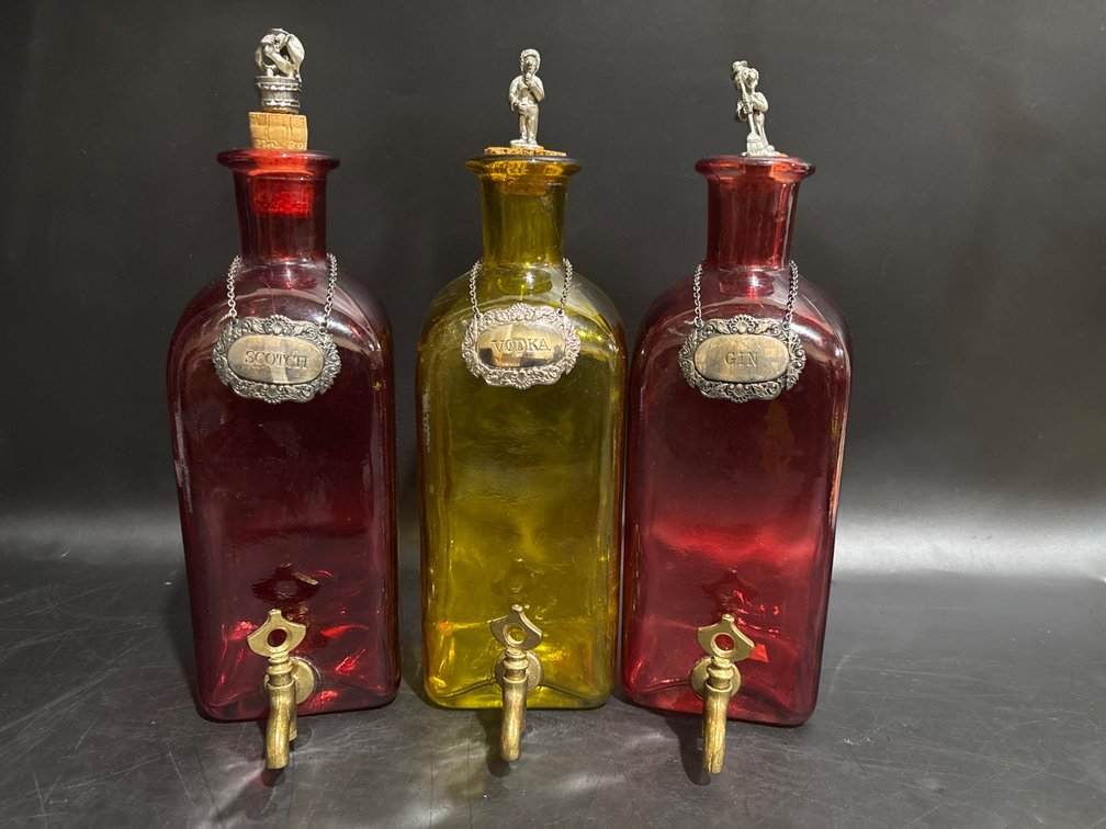 Three Glass Decanters with Metal Labels and Spouts
